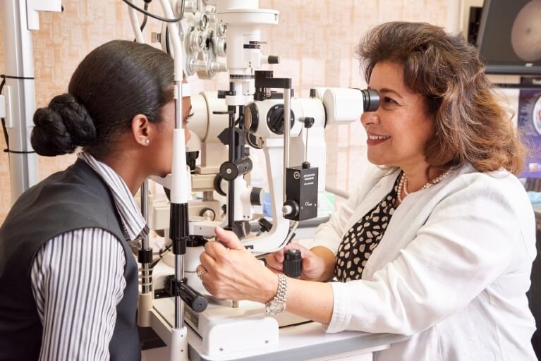 Dr Tereza Fawzy working with medical equipment examining a patient's eye.