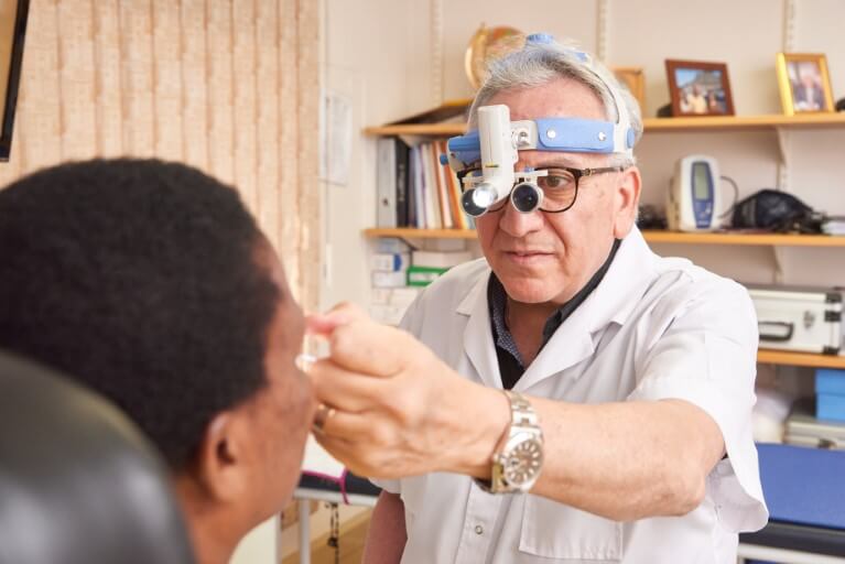 Dr Bassem Fawzy examining a patient's nose and throat.