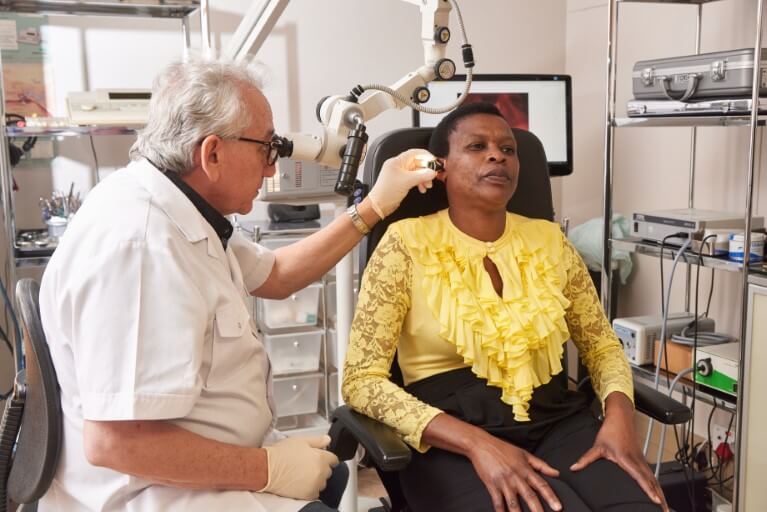 Dr Bassem Fawzy examining a patient's ear.