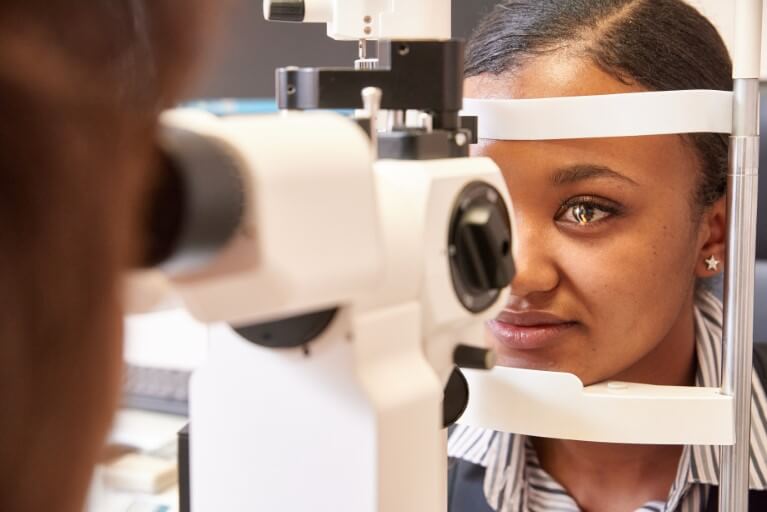 Dr Tereza Fawzy assessing a patients eye using medical equipment